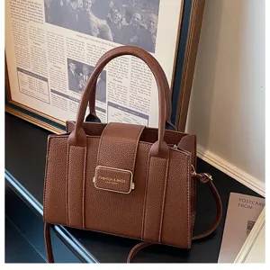 Detail de sac cabas en cuir PU marron, sac a main elegant avec poignee et boucle metal.