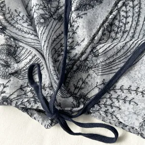 Close-up detail of French vintage lace layered skirt extender with dark drawstring.