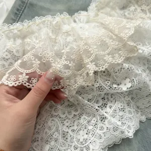 Detailed close-up of a white double-layer lace skirt extender with intricate paisley hollow design.