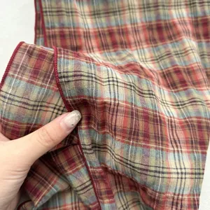 Nahaufnahme des Vintage-Karo-Stoffes mit feiner Textur und rotem Saumrand im Detail.