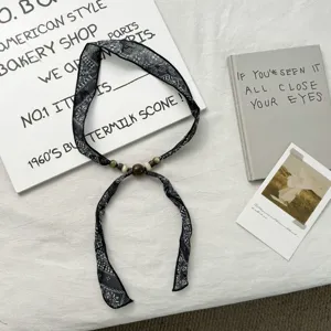 Black floral print skinny scarf with vintage beaded charm, elegant neck accessory for women.