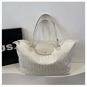Detailed view of the cream pleated travel shoulder bag showcasing its unique texture and large capacity.