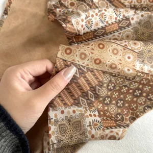 Close-up detail of retro ethnic printed cotton triangle scarf, showing soft texture and pattern.