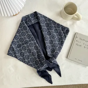 Detailed close-up view showing the retro botanical pattern texture of the dark blue triangular scarf.