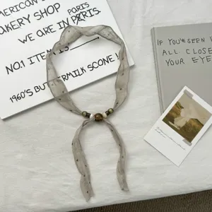 Detailed view of the vintage bead-decorated neck ribbon scarf, showing delicate dots.