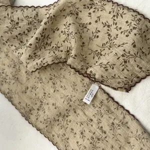 Detailansicht des Vintage Schals mit braunem Blattmuster und eleganter Stofftextur.