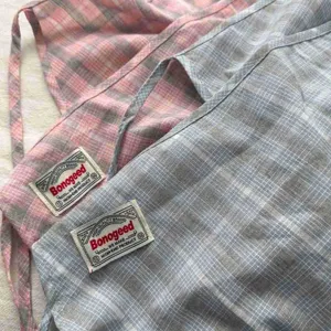 Detailed view of plaid layered half skirt fabric and woven label, vintage college style design.