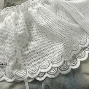 Detail zoom gelaagde rok van witte kant mesh stof, zeer delicaat geschulpte borduurlaag.