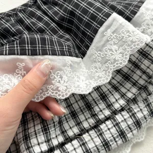 Vintage black and white plaid skirt extender with delicate white lace trim layering detail.