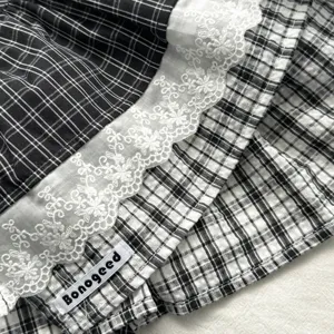 Vintage plaid layered skirt with delicate white lace trim and detailed fabric texture.