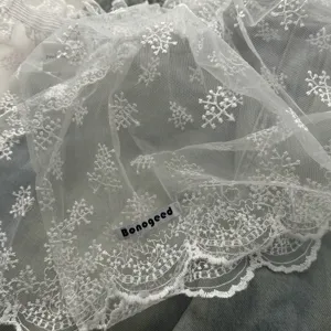White sheer lace fabric detail, delicate floral embroidery, lightweight sheer layered skirt trim.