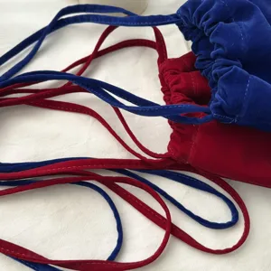 Velvet drawstring pouch detail shot, blue and red soft fabric bags with long straps for women.