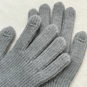 Close-up detail of grey knitted touchscreen gloves with ribbed texture, perfect for winter warmth.