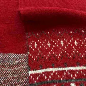 Dettaglio sciarpa in maglia rossa, morbido misto lana con motivo nordico festivo.