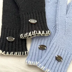 Detailed view of cozy winter knit gloves featuring chic button decor and warm fabric.