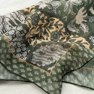 Nahaufnahme eines grünen floralen Paisleyseidentuchs, perfekt für Frühlingsbürokleidung.