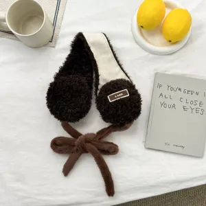 Cómodas orejeras de felpa marrón con bonitos detalles de lazos y textura suave para abrigarse bien.
