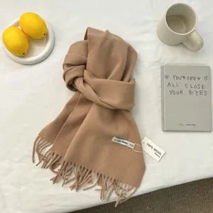 Primo piano dettaglio di una sciarpa invernale in lana cammello classica con frange.