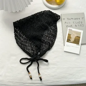 Detalle de pañuelo triangular de ganchillo negro, accesorio de moda muy elegante.
