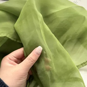 Gedetailleerd uitzicht op de lichte groene chiffon sjaal stof textuur, zacht en ademend.