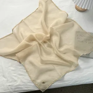 Lichte, doorzichtige vierkante sjaal in zacht crémegeel, perfect mode-accessoire voor de lente.