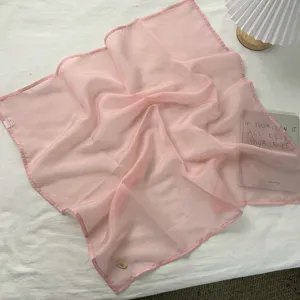 Lichtroze doorschijnende vierkante sjaal detail, zachte lichte stof, elegante nekaccessoire.