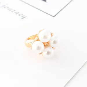 Gros plan détaillé d'une bague de perles dorée vintage et d'un élégant accessoire de boucle foulard.