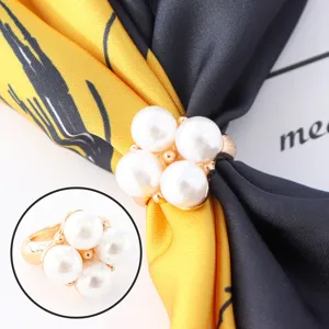 Vue détaillée de l'anneau de foulard en perles avec design floral élégant et base dorée.