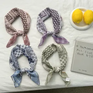 Dettaglio di foulard quadrato geometrico in stile bohémien, elegante accessorio donna.