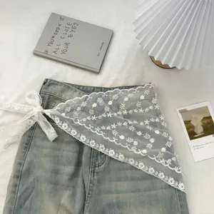 Gedetailleerd uitzicht op de koreaanse witte kanten driehoekige sjaal met jeans.