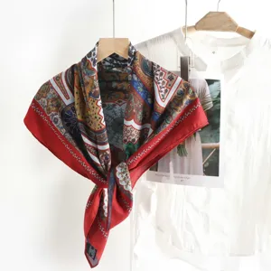 Close-up detail of vintage style large square silk scarf with retro print and elegant red border.