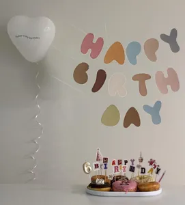 Detailed view of Morandi vintage color birthday banner, heart balloon and cake topper set.