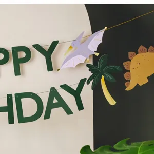 Dinosaur birthday banner party decoration details showing cute paper letters and dino cutouts.