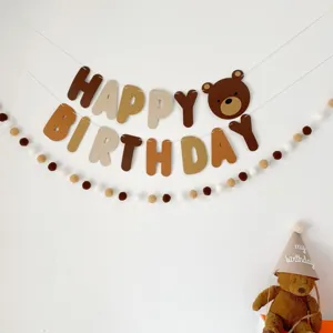 Brown bear felt banner and ball garland set for kids birthday party decoration closeup.