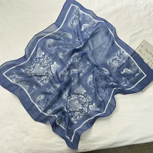 Nahaufnahme des eleganten blau-weißen Seidenschals mit traditionellem Paisley-Muster.