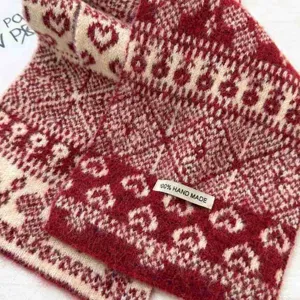 Close-up detail of the Fair Isle red vintage jacquard cross scarf showing winter warmth.