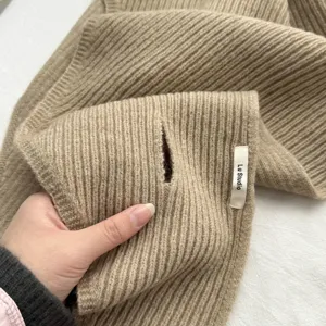Detalle de bufanda de punto acanalado para mujer con textura suave y diseño de abertura.