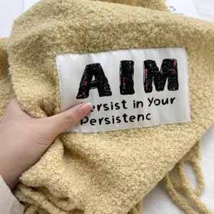 Detailed view of a cozy yellow wool fleece scarf showing fabric texture and stitched label.