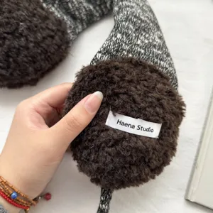 Nahaufnahme Detail von Winter Plüsch Ohrenschützern mit weichem Kunstfell und Strickriemen.