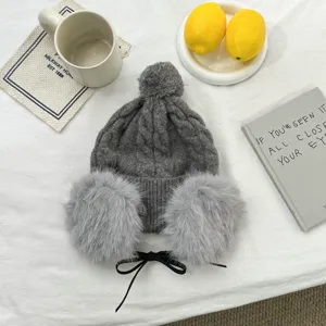 Winter warme Strick Mütze mit Ohrenklappen, Bommel und Bändern. Gemütliche graue Damen Beanie.