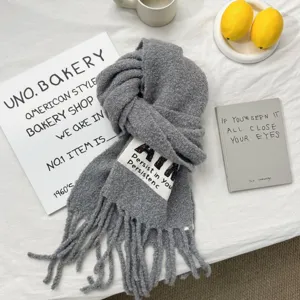 Grey knitted winter scarf with tassels detail, cozy textured warm wrap for cold weather.