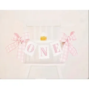 Pink plaid first birthday high chair banner with bow, perfect for baby party decor.