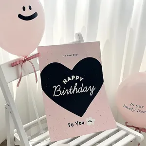 Detailed view of pink birthday poster card with cute smiley balloons and bow ribbon setup.