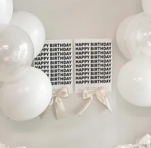 Detail shot of minimalist birthday party wall card decoration featuring elegant bow ribbons.
