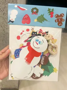 Christmas paper cutout set detail featuring snowman and gingerbread man with hanging twine.