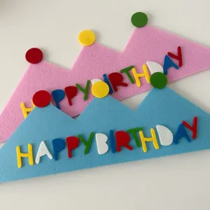 Close-up detail of colorful felt birthday crown with letters, ideal party decoration accessory.