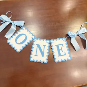 Detail shot of blue and white ONE birthday banner with cute ribbon bows for party decor.