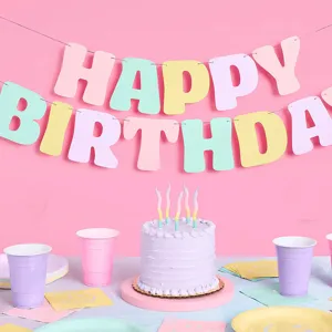 Pastel happy birthday party banner set with matching cake and tableware decorations detail.