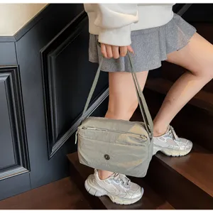 Detailed shot of a lightweight nylon crossbody shoulder bag featuring a chic pleated design.