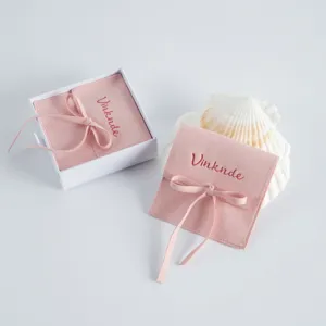 Sacchetto per gioielli in velluto rosa con fiocco e scatola bianca, ideale per anelli e collane.